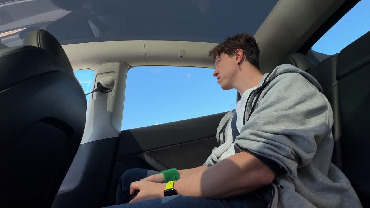 Person sitting in the backseat of a Tesla