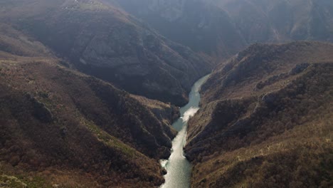 aerial shot of matka canyon showcasing the river winding between rugged mountains