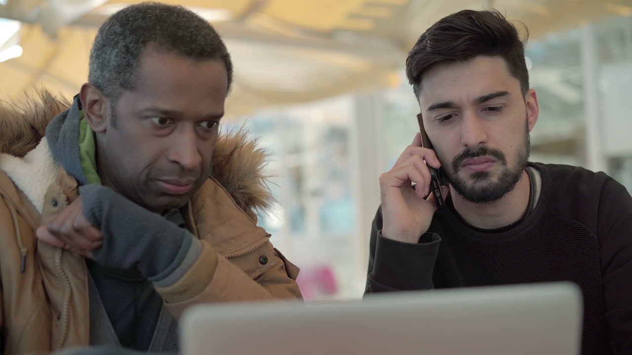 Focused freelancers working with laptop and smartphone