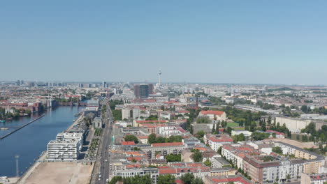 Volar-Por-Encima-De-La-Ciudad.-Vista-Aérea-Panorámica-Del-Barrio-Urbano-En-El-Río-Spree.-Torre-De-Televisión-Fernsehturm-En-La-Distancia.-Berlín,-Alemania