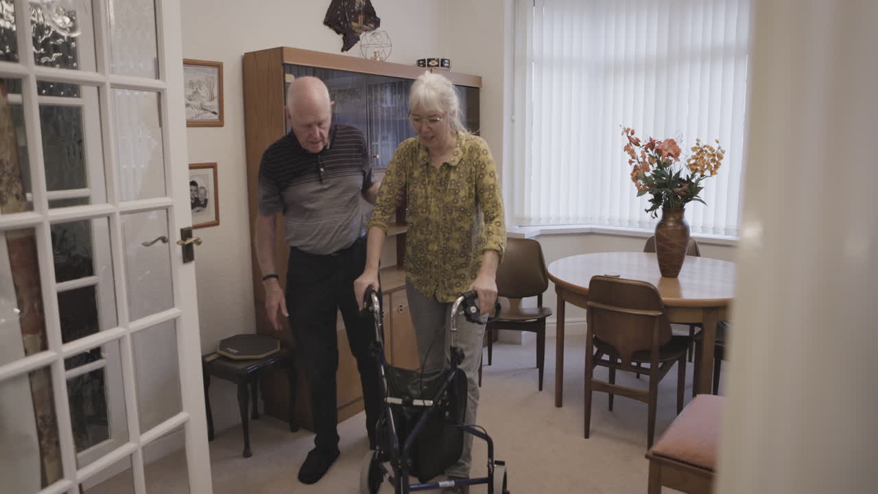 Senior couple with walker in living room