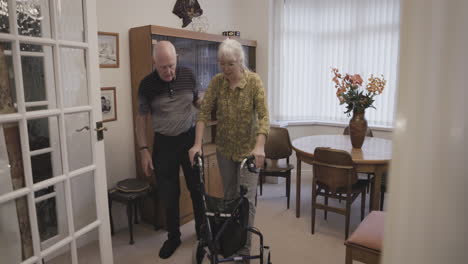 senior couple with walker in living room