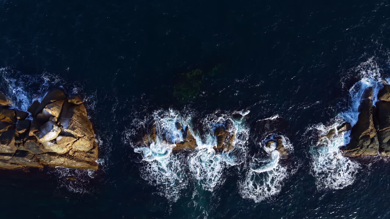 Waves crashing over rocky shores create a breathtaking view of nature's beauty at sunset along the coastline