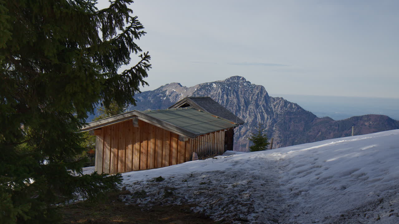 Wooden Mountain Cabins On A Snowy Slope With View Of Rugged Peaks In The Bavarian Alps, Berchtesgaden, Germany. wide shot