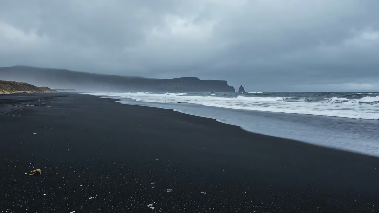 Black Sand Beach with Waves and Cloudy Sky