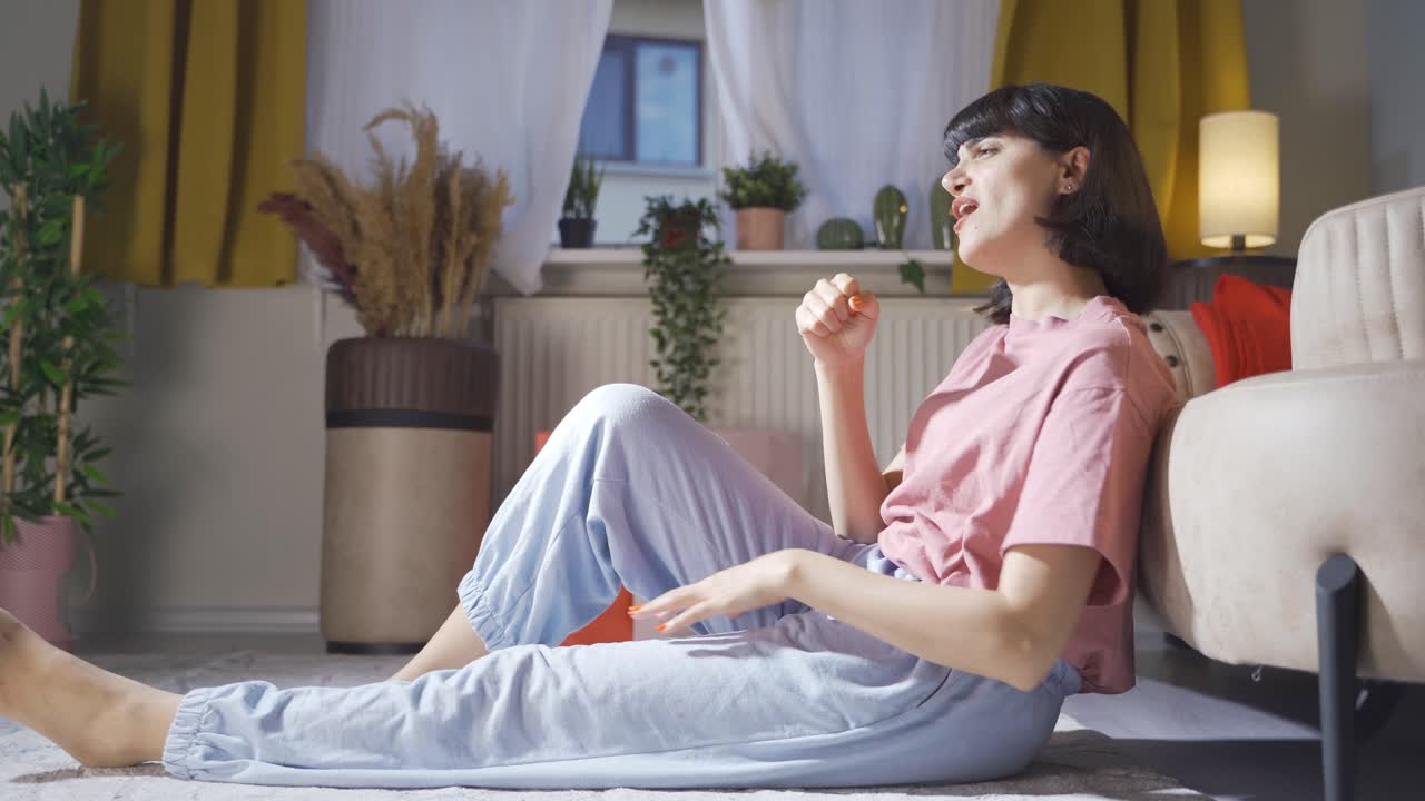 여자는 집에서 자기 자신에게 노래를 부릅니다. 그녀는 편안하고 행복합니다.