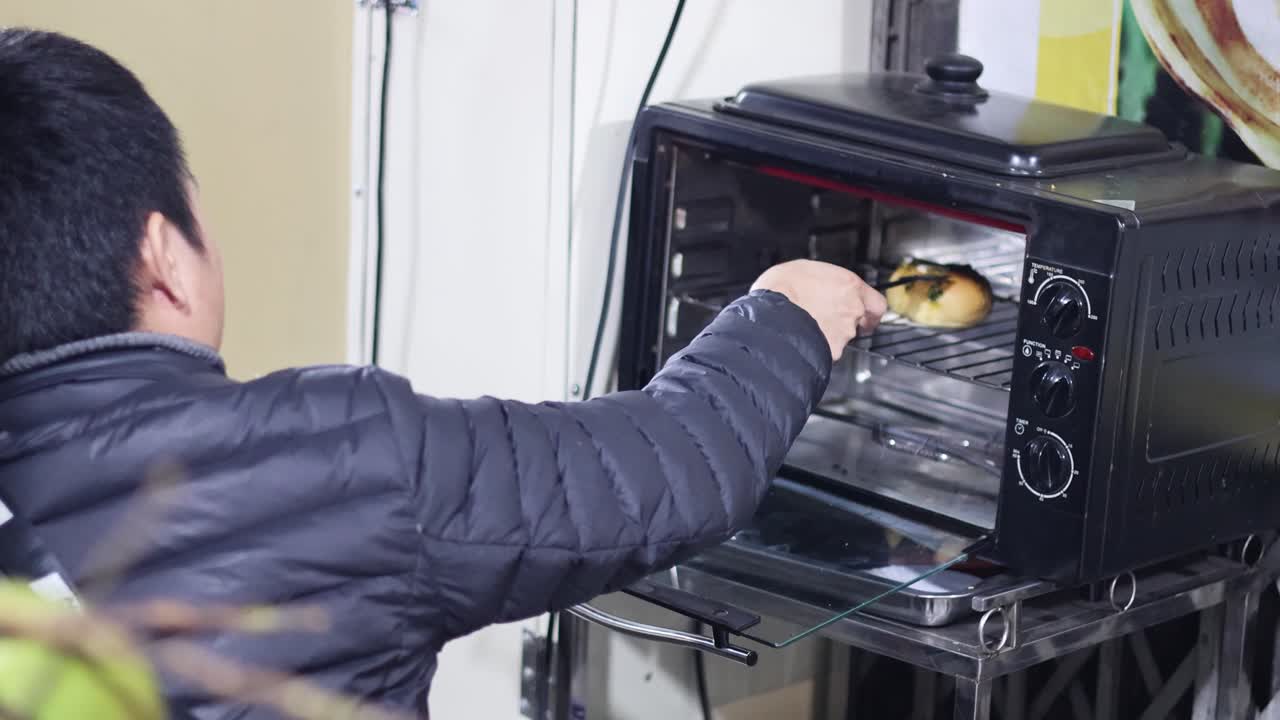 Persona che prepara cibo usando un forno tostapane