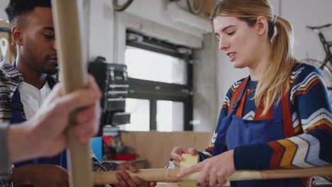 Multi-Cultural-Team-Of-Trainees-In-Workshop-Assembling-Hand-Built-Bicycle-Frame-Together