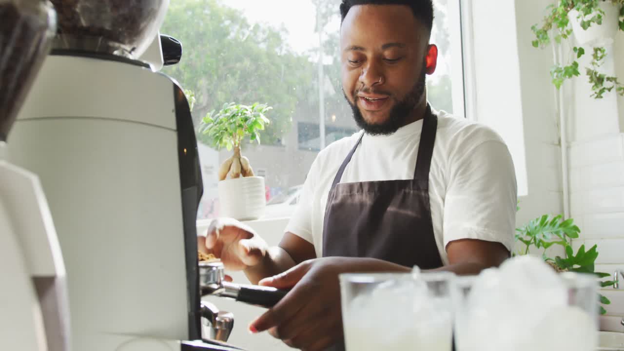 barista afro-americano feliz fazendo café usando máquina de café em um café