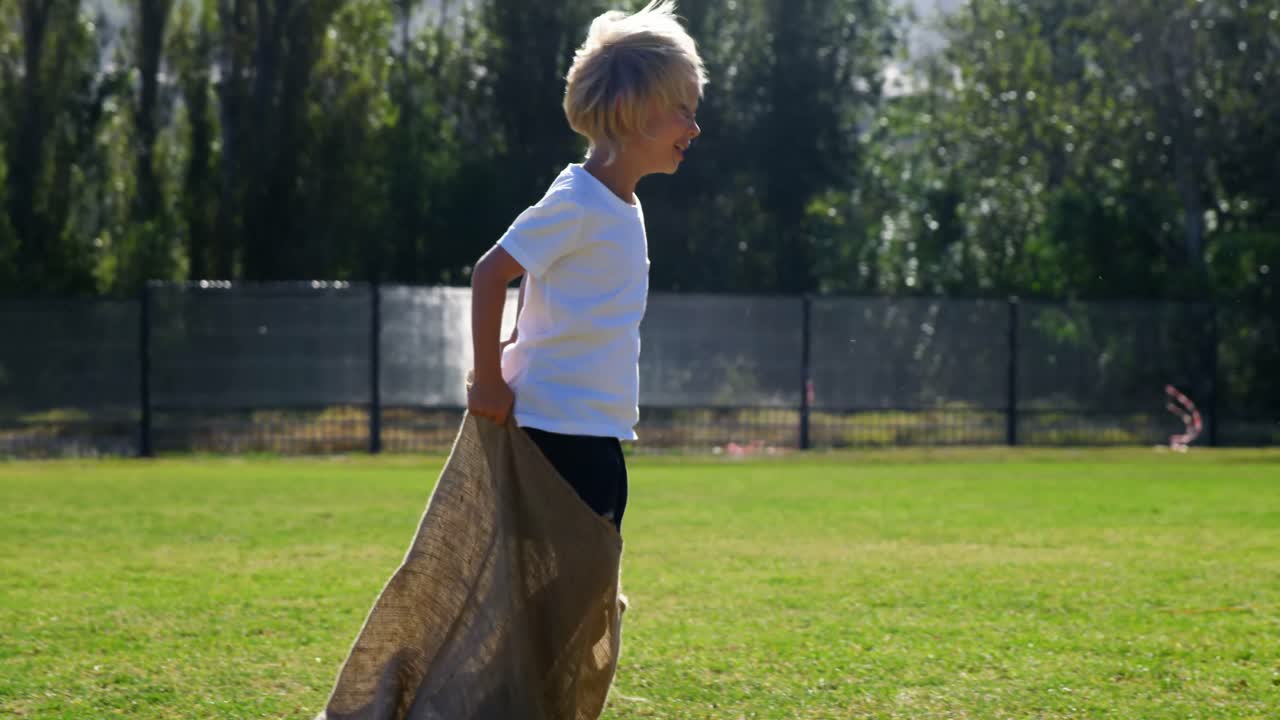 niños jugando una carrera de sacos en el parque