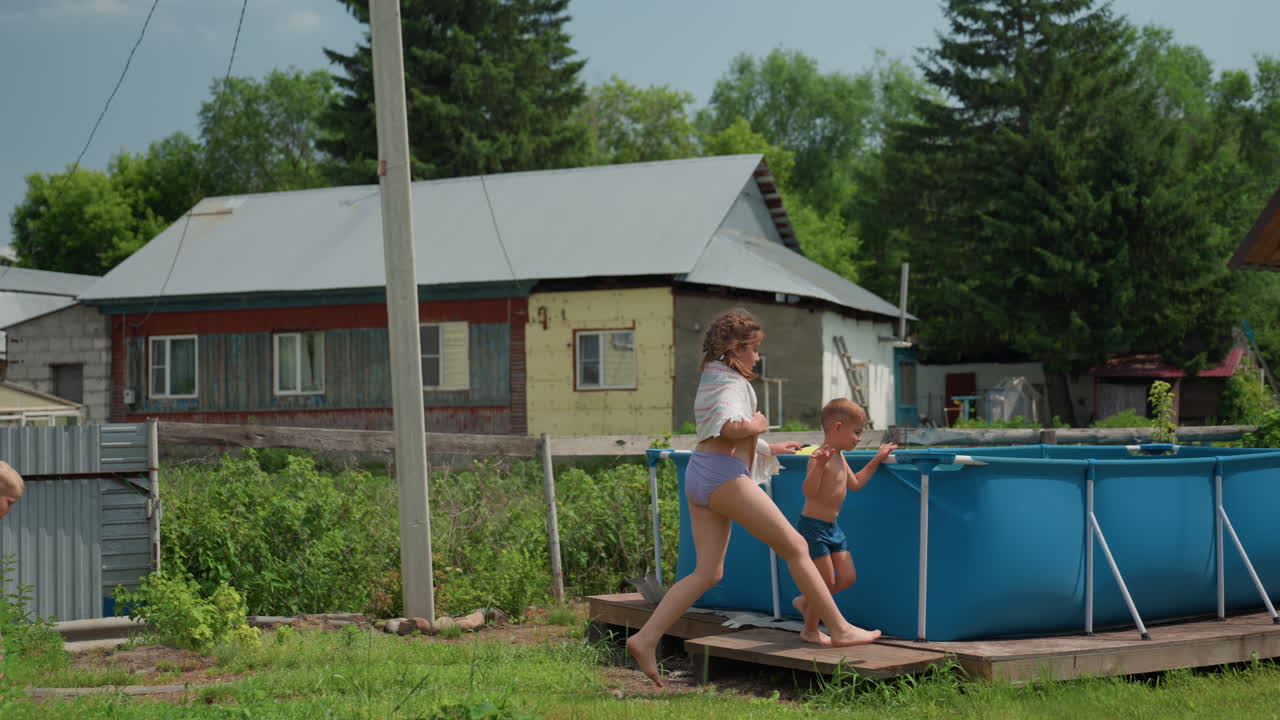 Jeune garçon plein de vie courant le long d’un sentier de jardin, passant devant une serre pour rejoindre la piscine. Garçon énergique, pieds nus, traversant une arrière-cour ensoleillée, passant devant une serre en direction de la piscine dans une ambiance estivale