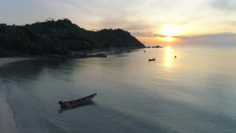 stunning sunset over tropical beach with boats in the water