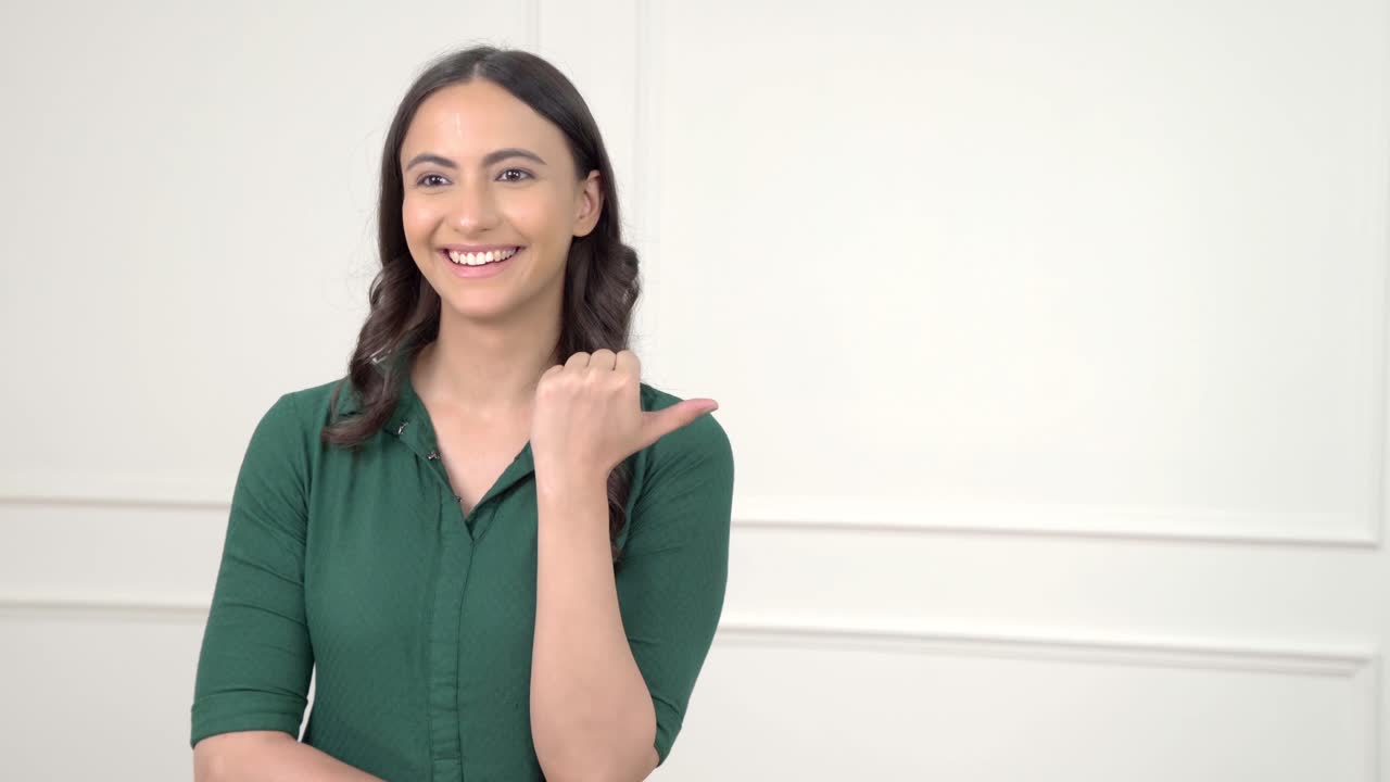 mujer india apuntando a la derecha en el espacio de copia