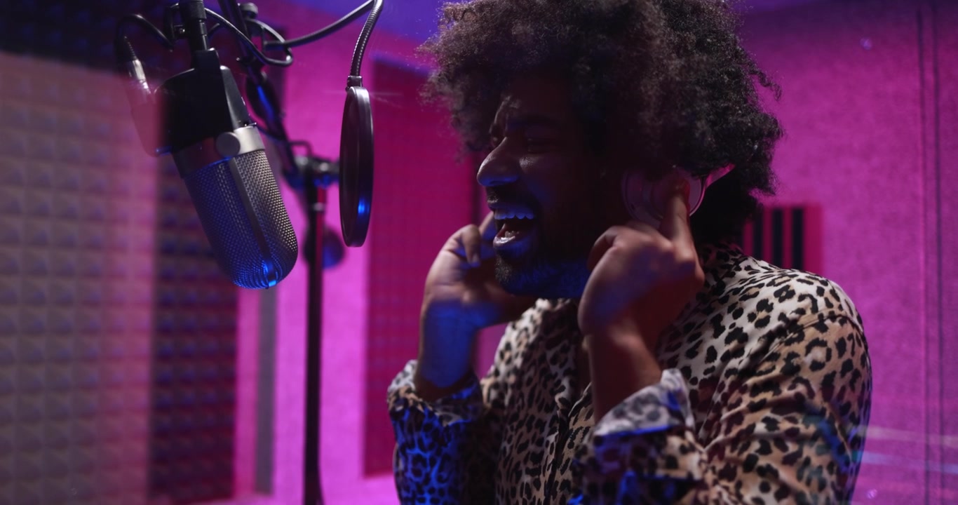 Passionate Man Singing into Microphone in a Vibrant Recording Studio