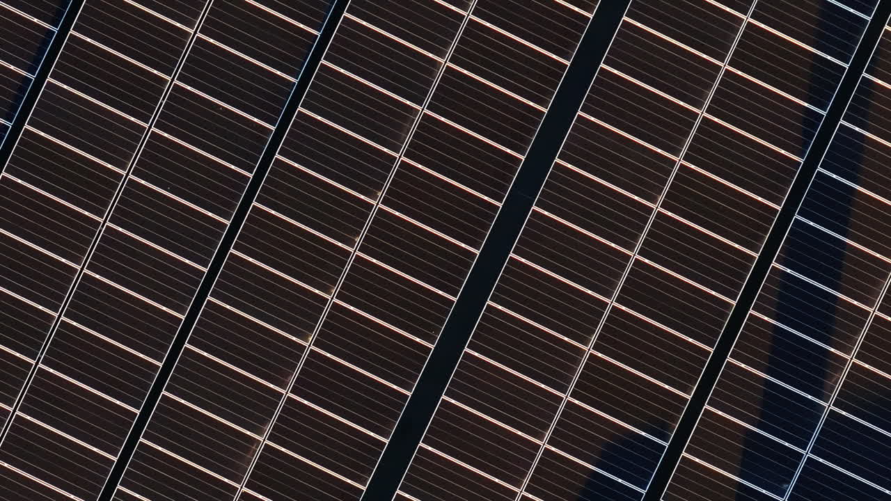Aerial drone view of solar panels at sunset. Photovoltaics on top of the roof of the building. Alternative electricity source. Concept of sustainable resources