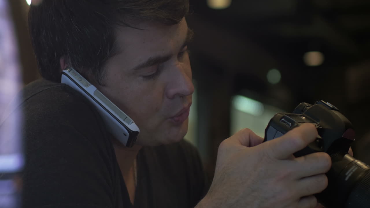 전화로 이야기하고 카메라를 사용하는 남자