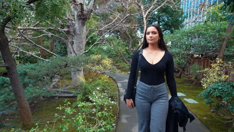 a-4k-slow-motion,-stabilized-video-depicting-a-beautiful-young-arabic-female-model-exploring-a-lush-Japanese-Tea-Garden-walking-along-a-garden-path,-peninsula,-california