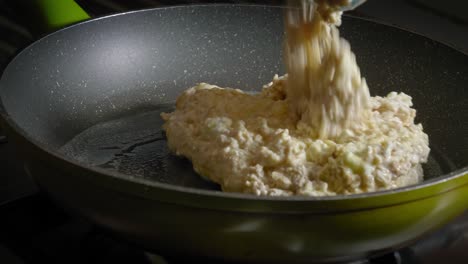 Verter-La-Mezcla-De-Avena,-Huevos-Y-Queso-En-Una-Sartén-Caliente-Con-Mantequilla-Derretida