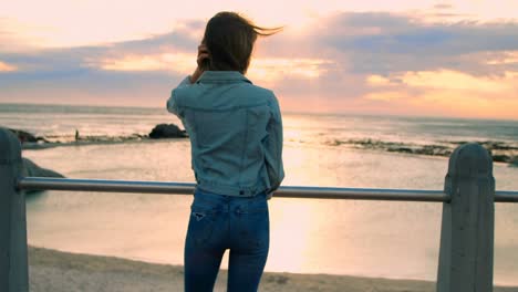 Woman-standing-near-railings-at-beach-4k