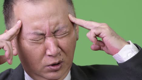 두통 을 고 있는 성숙 한 일본인 사업가