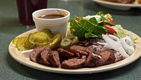 Close-up-shot-of-fried-meat-fillet-with-fresh-vegetable-salad-of-tomatoes,-cucumbers,-onion-and-lettuce-served-on-white-plate