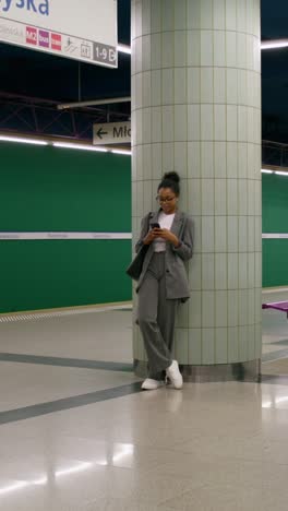 woman using smartphone in a subway station