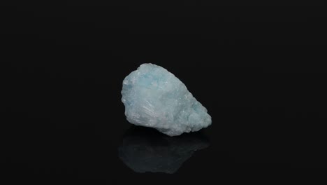 una roca azul gira y cambia de posición en la superficie negra