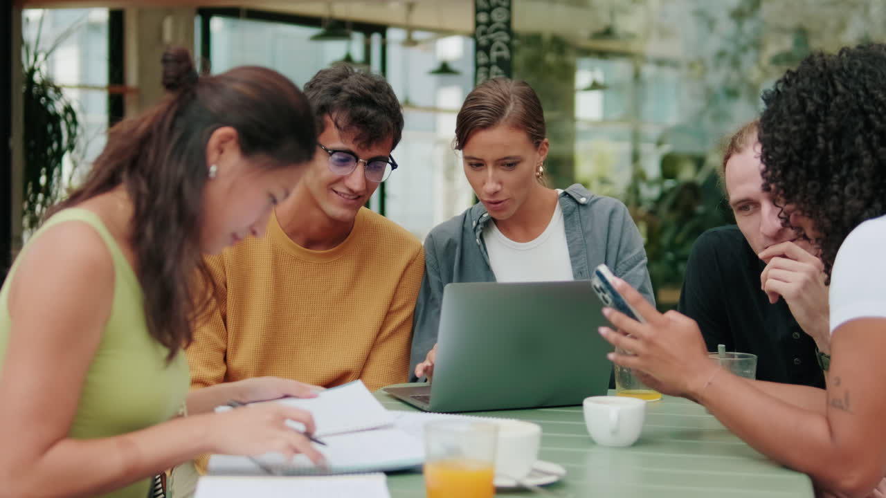Top view of international joyful students using laptop or modern technologies