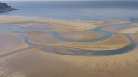 aerial birds eye shot of sandy raudasandur beach and ocean in background in summer - iceland, europe