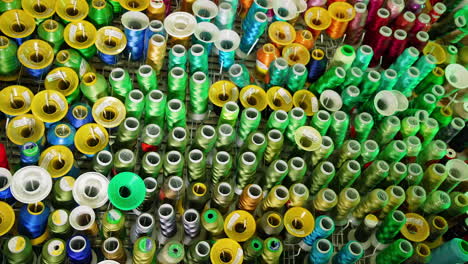 Sewing colorful threads hanging on a wall. Design cotton accessories.
