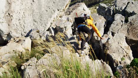 Senior-woman-climbing-rock-at-countryside-4k