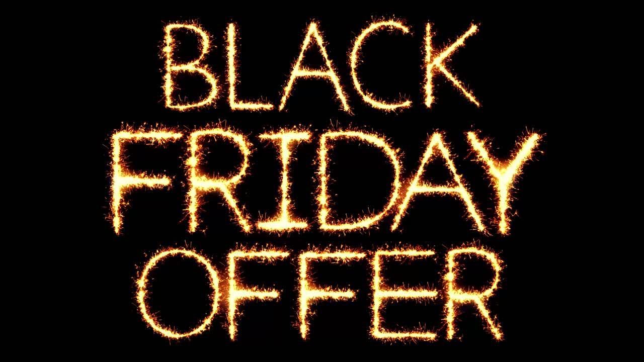 Teks 'Penawaran Black Friday' tulisan kembang api dengan percikan kilau dan partikel kembang api pada loop 4K hitam