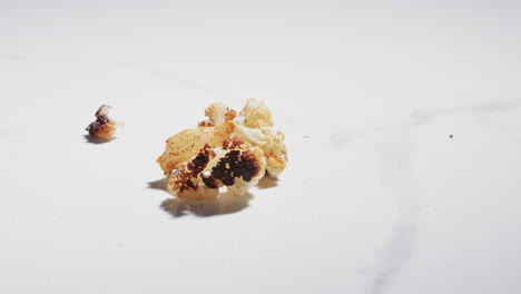 dropping roasted cauliflower onto a counter