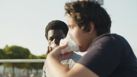 Happy-multiethnic-friends-cheering-and-eating-pastries