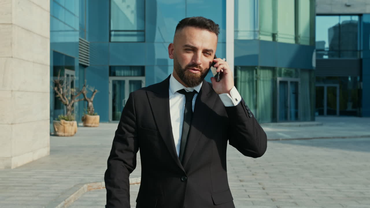 hombre de negocios hablando por teléfono fuera del edificio de oficinas