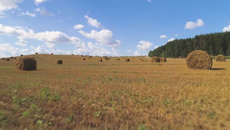 flying over hay bales in a field. flight at low altitude.