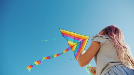 mujer joven jugando con la vista inferior de la cometa