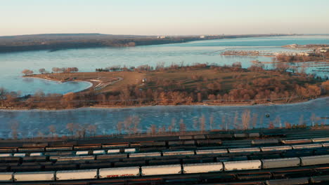 Toma-Aérea-De-Un-Parque-Junto-Al-Lago-Cerca-De-Un-Terreno-Industrial