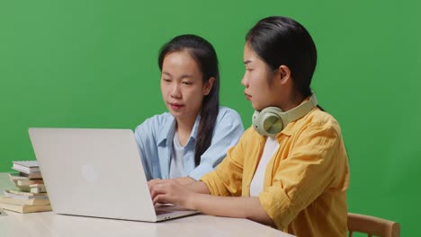 dos estudiantes colaborando en una computadora portátil