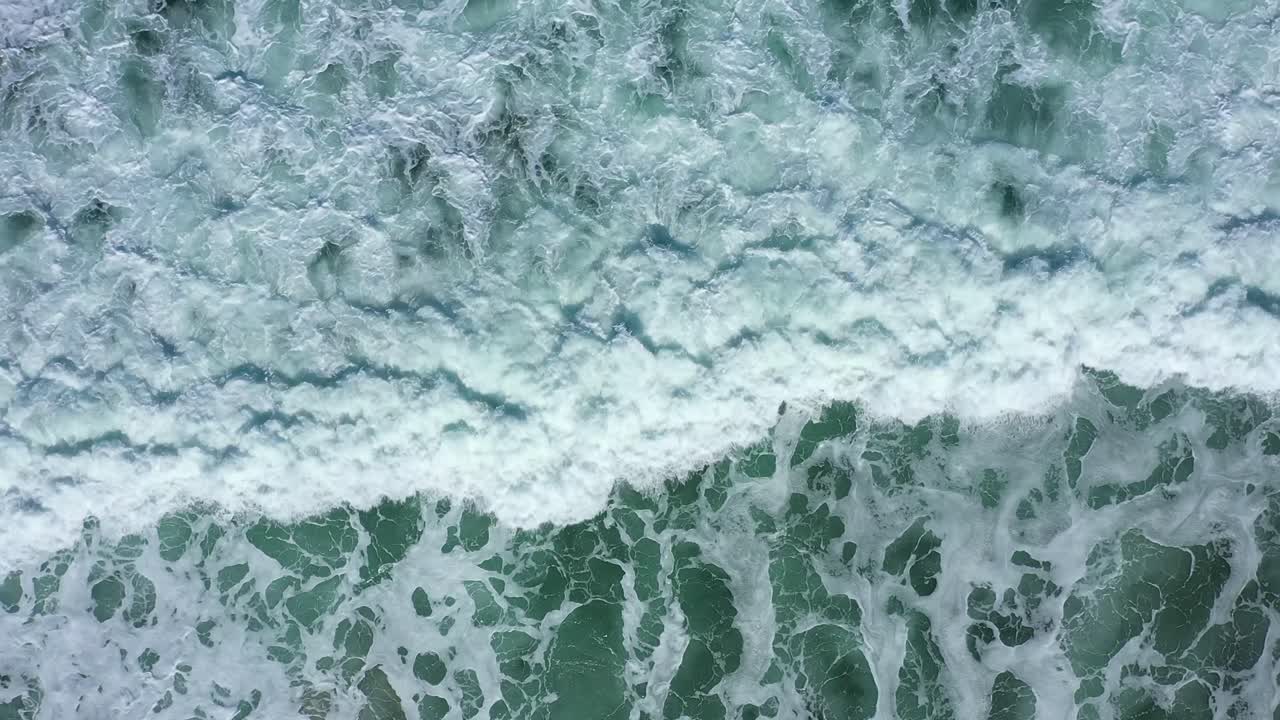 Top down shot of waves on the west coast crashing in slow motion