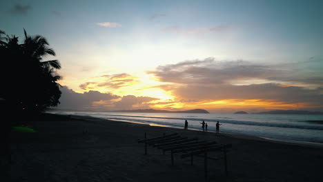 Cámara-Lenta-De-Siluetas-Caminando-Por-La-Playa-En-Filipinas-Y-La-Puesta-De-Sol-Está-En-El-Fondo