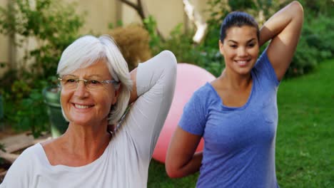 Senior-woman-with-female-trainer-doing-stretching-exercise-in-garden-4k