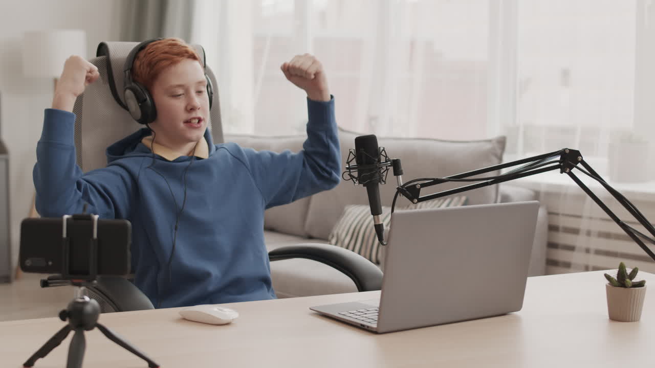 Teenager streaming online with computer and microphone