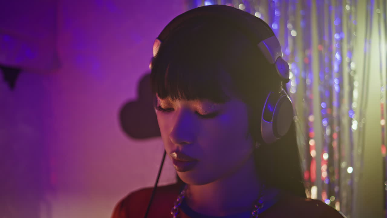 Woman disc jockey enjoy nightlife with headphones in colorful disco club closeup