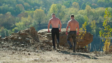 muscular strong fit athletes. rear view of handsome young athletes outdoors