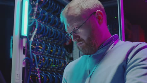 man working on server racks in a data center