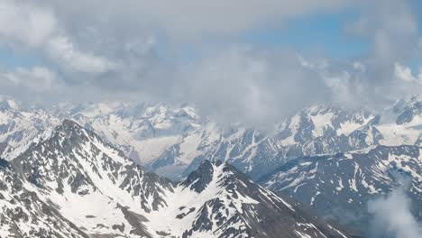 vuelo aéreo a través de nubes montañosas sobre hermosos picos nevados de montañas y glaciares.