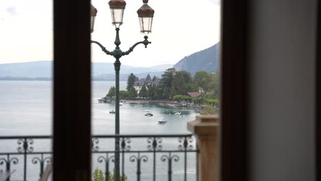 Lago-Annecy-Visto-Desde-Una-Ventana-En-Un-Día-Nublado-En-Los-Alpes-Franceses-Con-Farola,-Plano-Medio