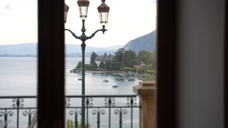 lake annecy seen from a window on an overcast day in the french alps with lamppost, medium shot