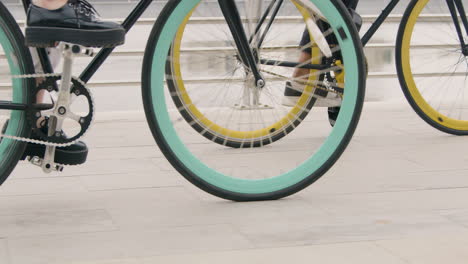 close up of two unrecognizable people riding bikes on the city bridge 1